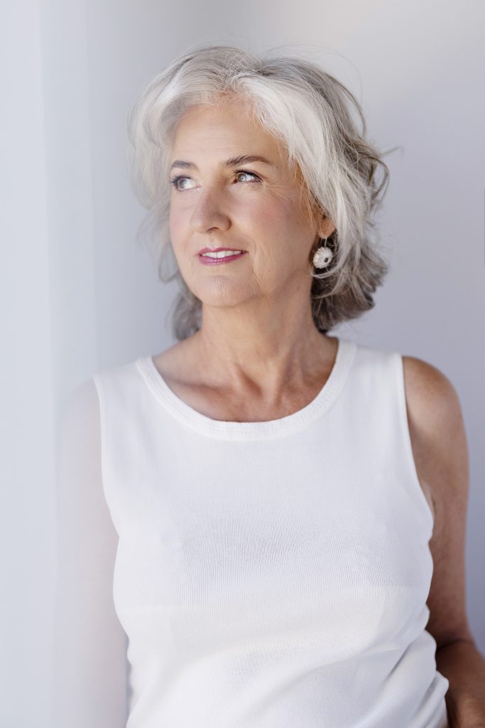 Natural window-light portrait of Ginette with silver hair and gentle smile