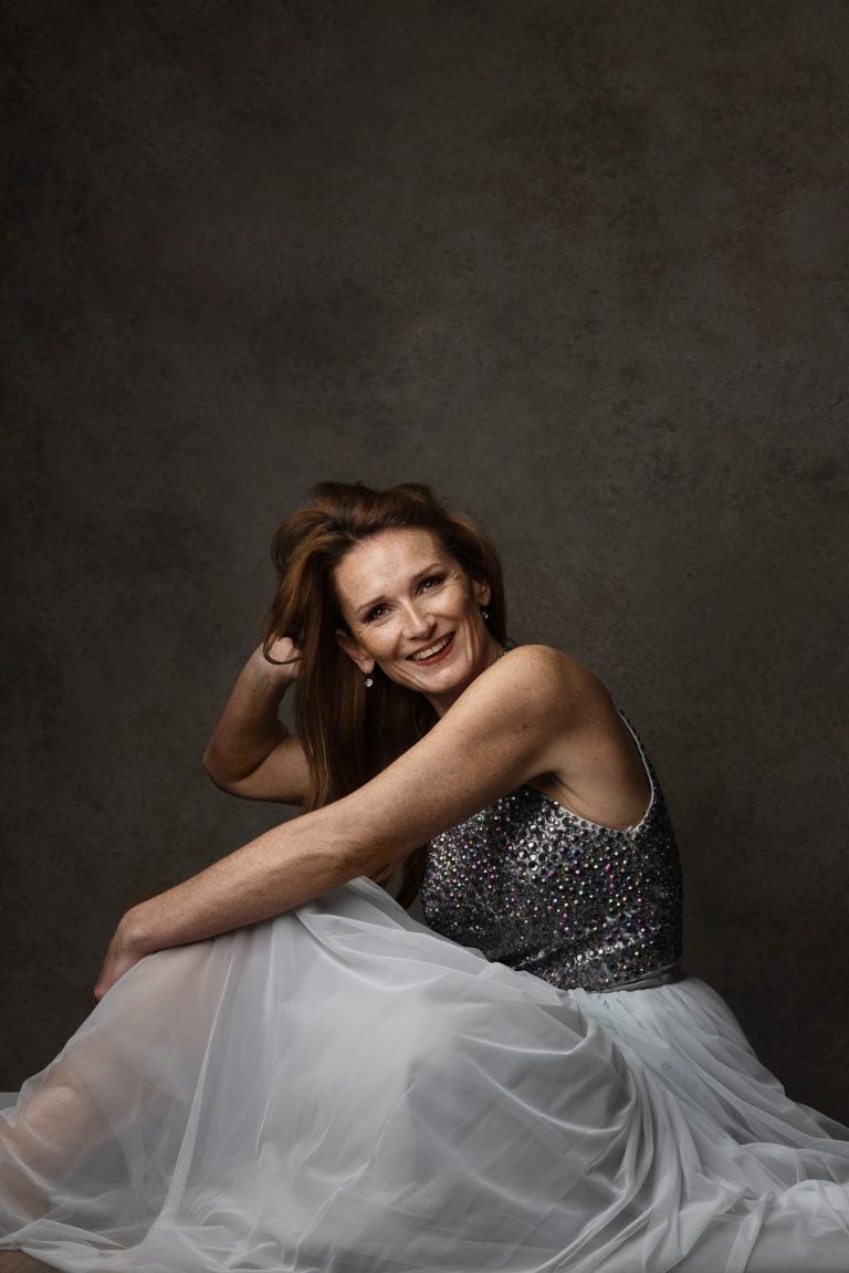 Elegant portrait of Sandy in a glitter dress, smiling gracefully, 40 over 40 campaign