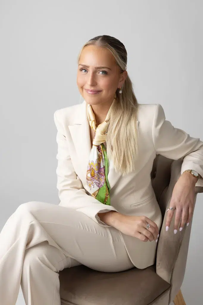 Elegant personal branding portrait of a woman seated in a light-toned studio setting in Luxembourg
