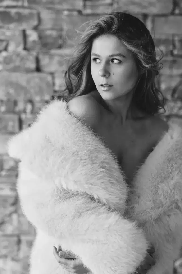 Black and white fine art portrait of a woman wrapped in soft faux fur in Luxembourg