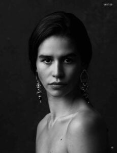 Black and white fine art close-up portrait from a Moevir Magazine editorial, photographed by Alena Massen, featuring dramatic studio lighting and statement earrings