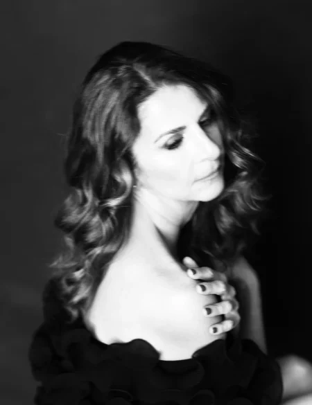 Black and white photo of Nathalie with a soft, thoughtful expression, captured in an artistic style