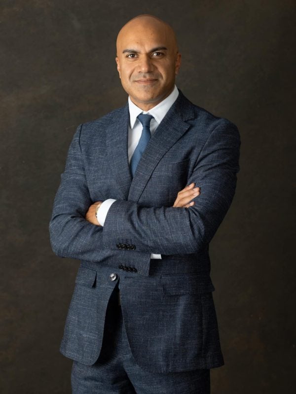 Professional portrait of a confident man in a tailored blue suit.